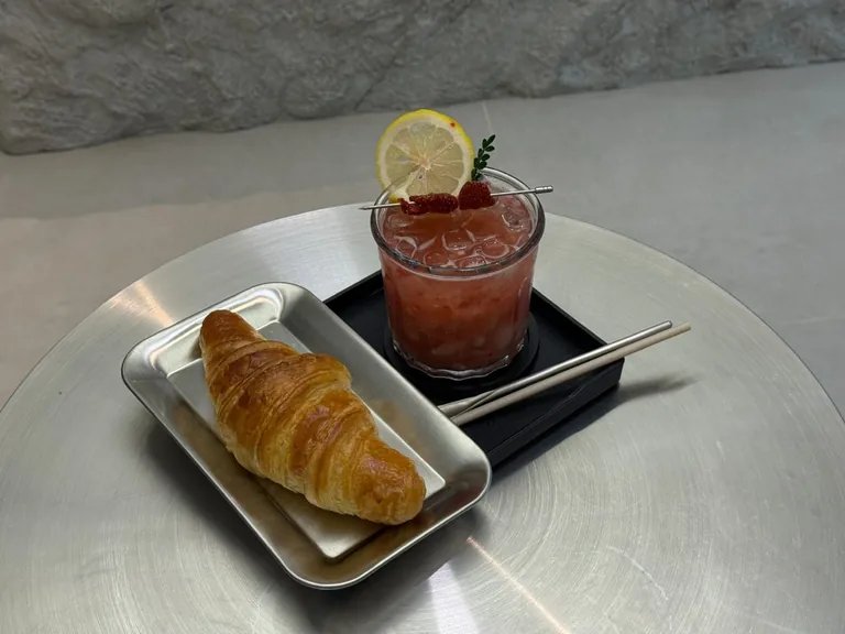 Đồ uống signature và croissant trên khay thép tại SOLUS